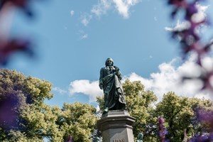 Staty i Humlegården - blommor i förgrunden
