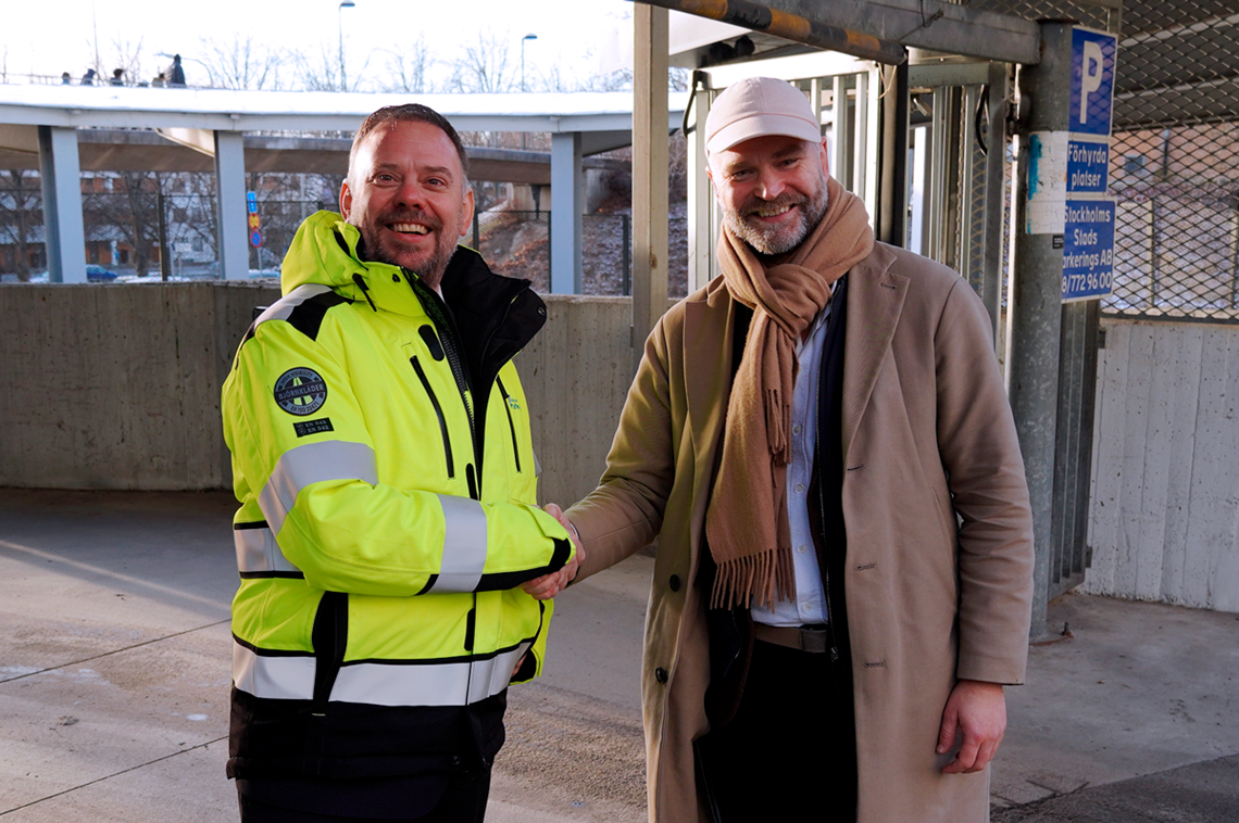 två personer ler och skakar hand