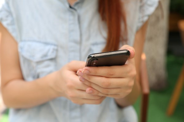 Person håller i en smartphone för att använda Betala P